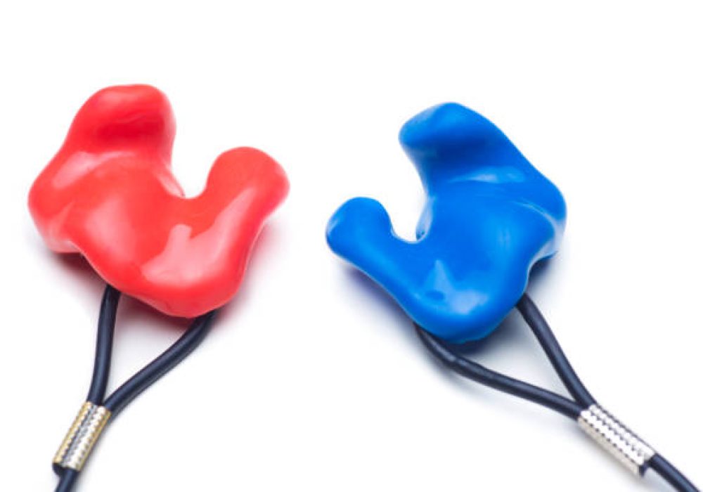 IMG_5171 Close-up of customized earplugs of silicone for hearing protection or swimming in red and blue isolated on white background